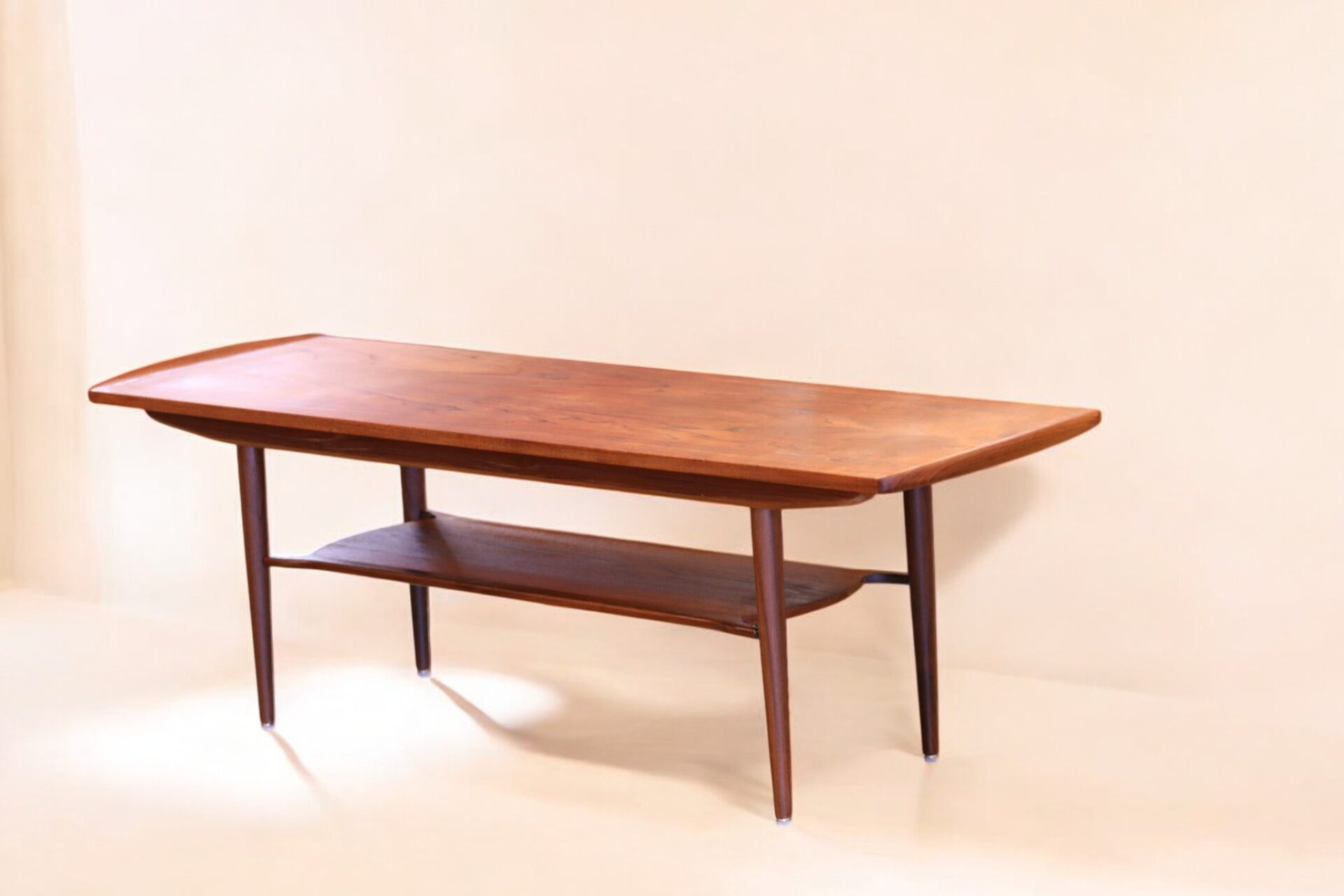 Läs mer om artikeln Danskt soffbord i teak med tidningshylla och kälad kant. 154x51x52 cm